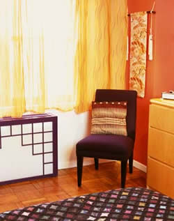 
Artist Lan Nguyen helped Amy and Oscar dress up the bedroom with an eggplant-colored radiator cover. Amy chose the silk curtains and brilliant-orange Benjamin Moore Eco-Spec paint because the bright colors 'just make me happy.'
